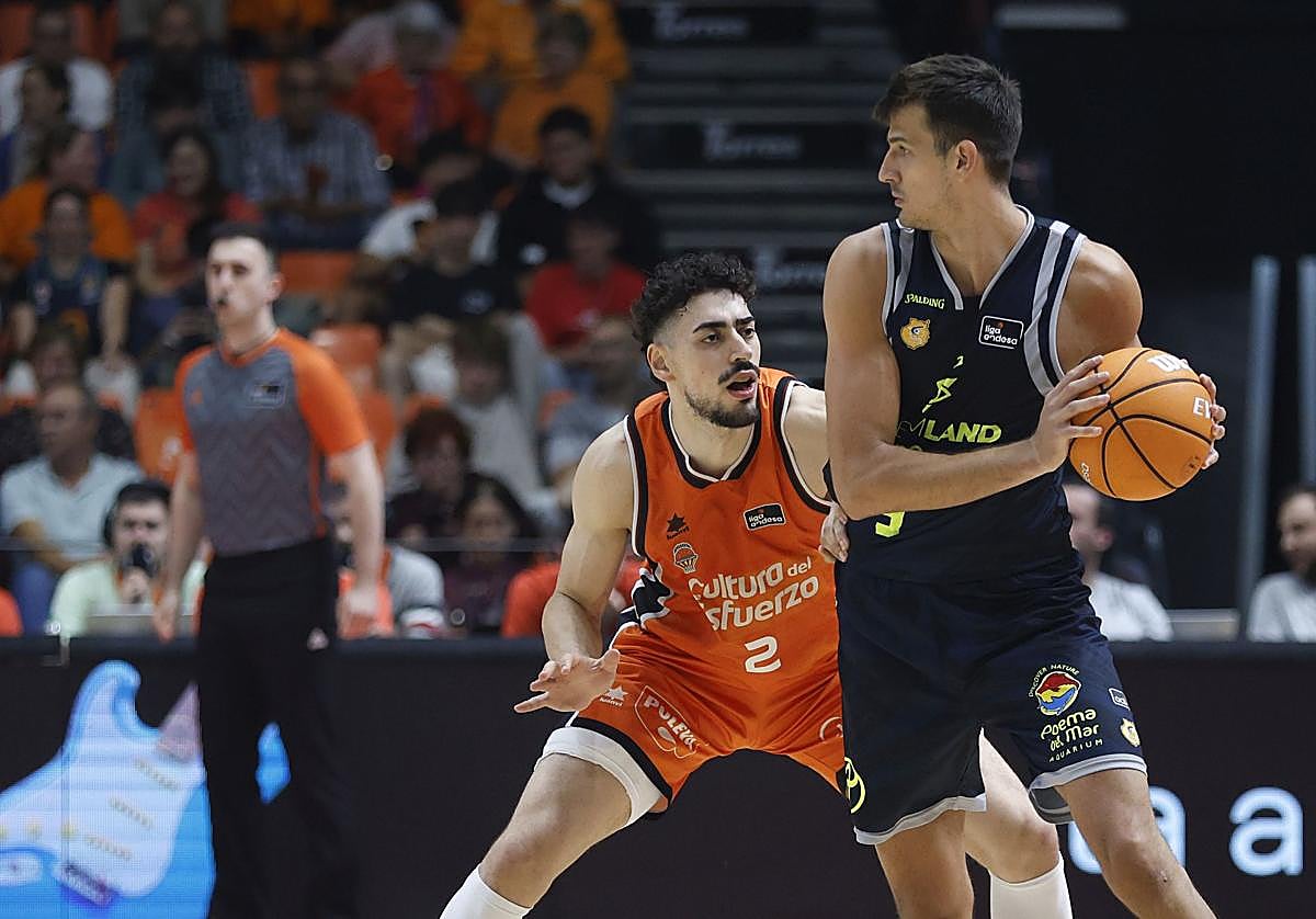 El alero argentino del Gran Canaria, Nicolás Brussino, protege el balón ante la defensa de Puerto.