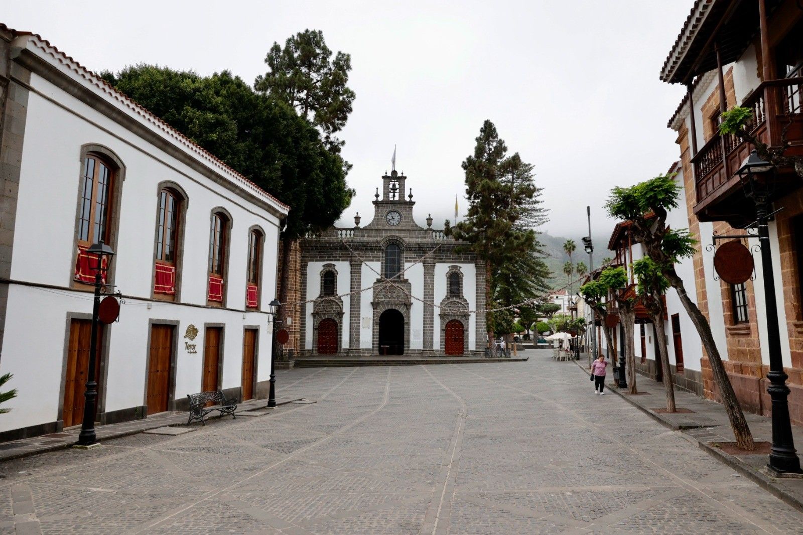 Imagen de la calle Real, con la Basílica al fondo, este mediodía. La ausencia de la Virgen del Pino se nota en Teror.