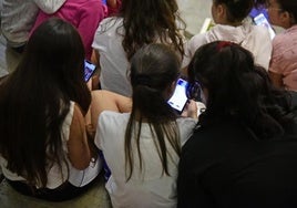 Jóvenes inmersas en sus dispositivos móviles.