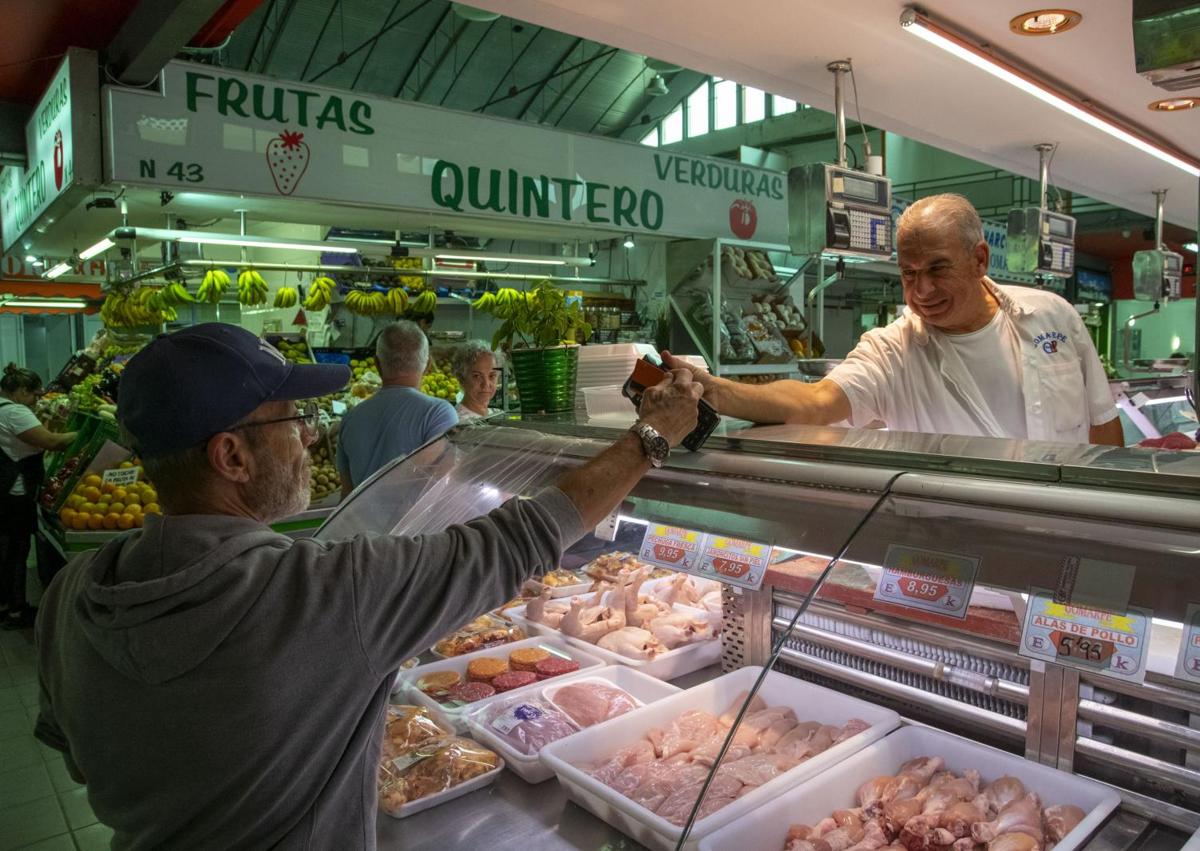 Imagen secundaria 1 - Ramón Guerra, en su puesto en el mercado de Altavista. Juan Manuel Martínez comprando. Y la vecina Bárbara Concepción.
