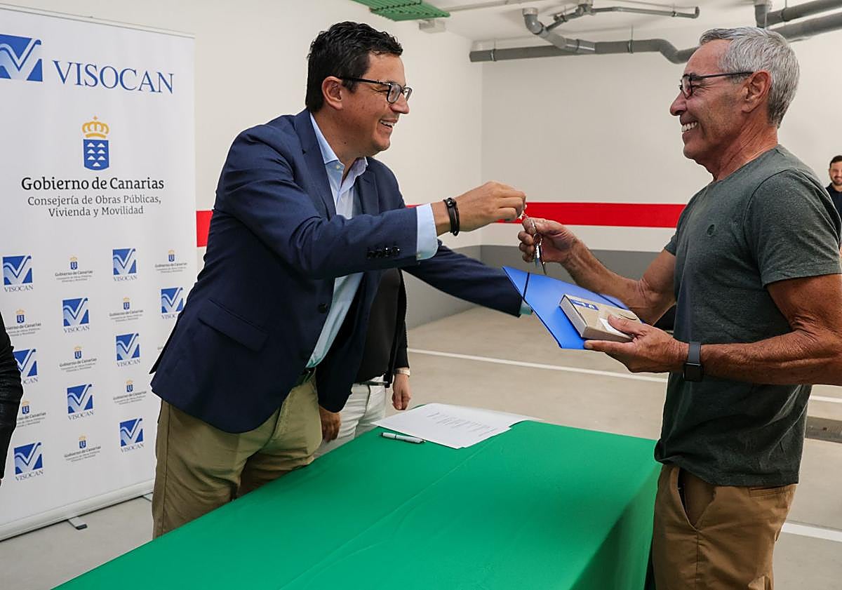 Imagen principal - Juan Martín y Reinhard, recibiendo las llaves, además del nuevo edificio con nueve viviendas.