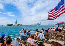 Turistas fotografiando la Estatua de la Libertad en Nueva York.