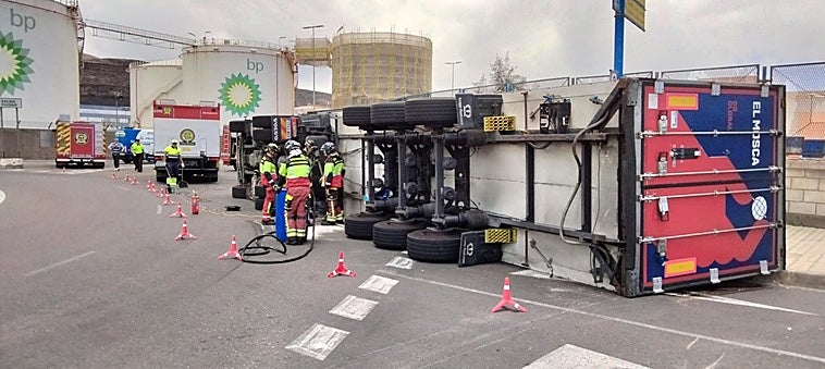 Imagen del camión volcado mientras es atendido por los bomberos.