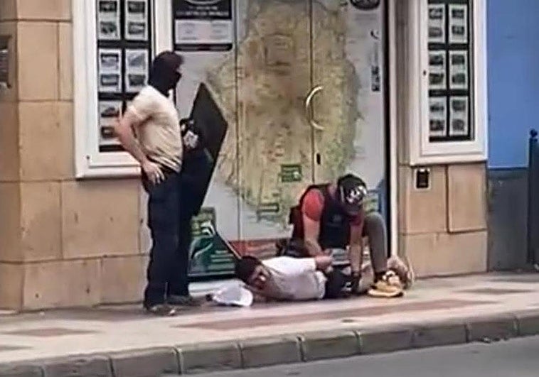 Dos agentes, junto a uno de los detenidos el sábado en la calle Presidente Alvear.
