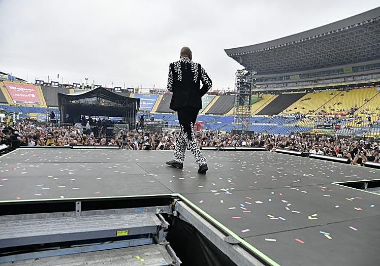 La grada curva del Estadio, cubierta con lonas publicitarias en el concierto de Efecto Pasillo.
