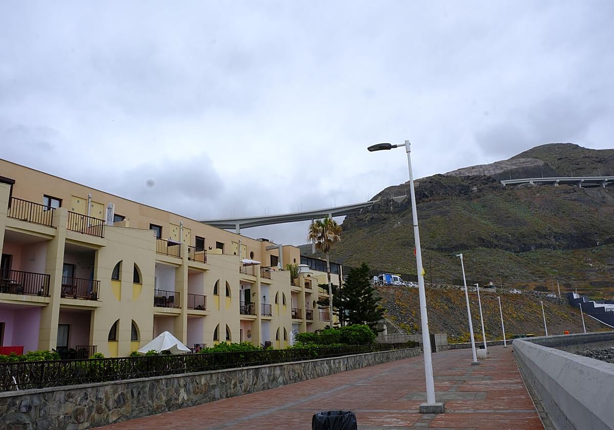 Imagen principal - Complejo de viviendas en el paseo marítimo de San Felipe, zona donde se rodó el videoclip de la canción de Quevedo, 'Lisboa', y el mar bravo.