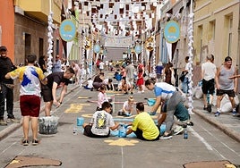 Los vecinos trabajan en la elaboración de una alfombra en la calle Menceyes.