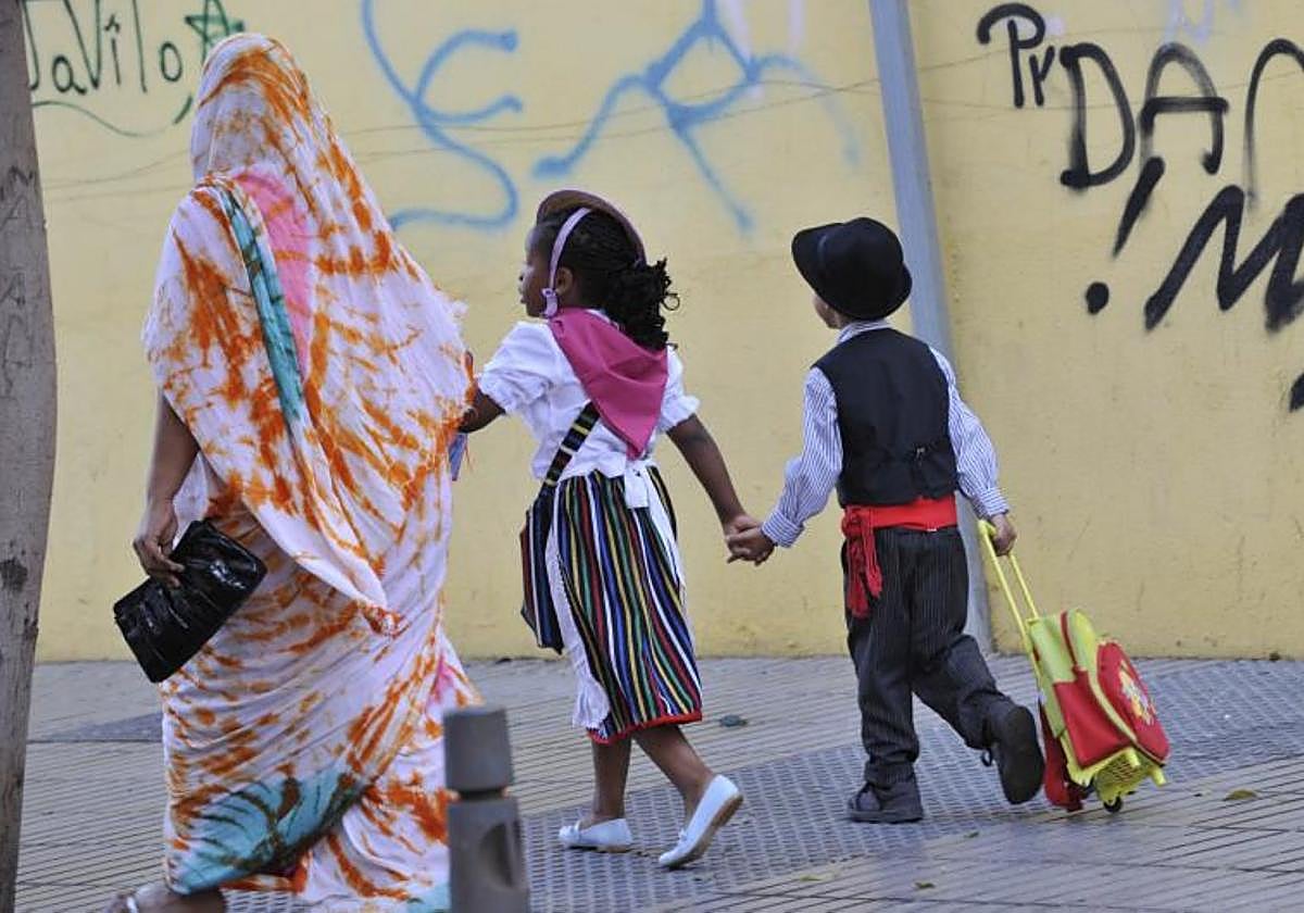 Una mujer lleva al colegio a sus dos hijos en la celebración del Día de Canarias.