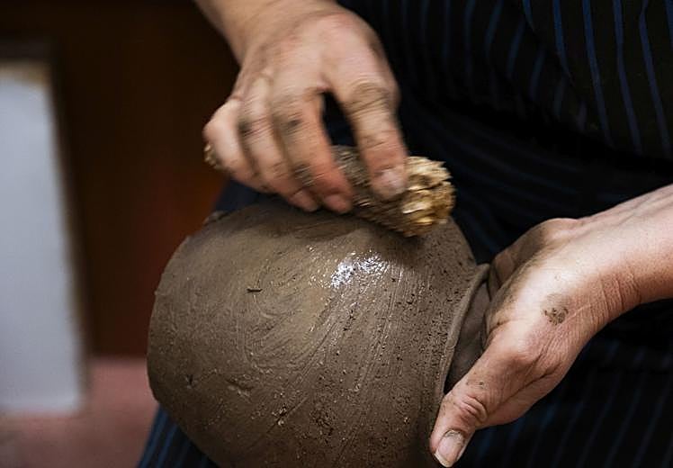 Las manos de María trabajando una de las piezas, listas para secar y posteriormente guisar al aire libre.