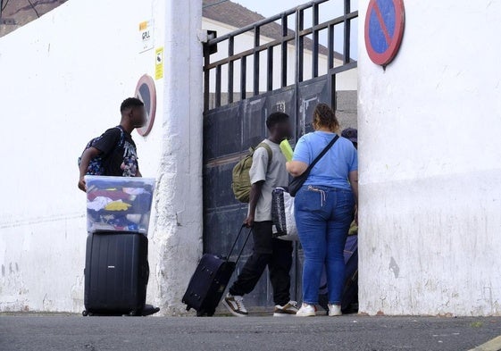 Dos menores junto a la trabajadora que los acompaña a ingresar al Canarias 50 en la tarde de este miércoles.