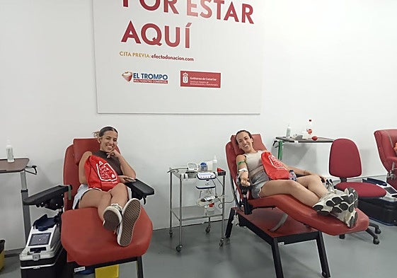 Dos chicas donan sangre.