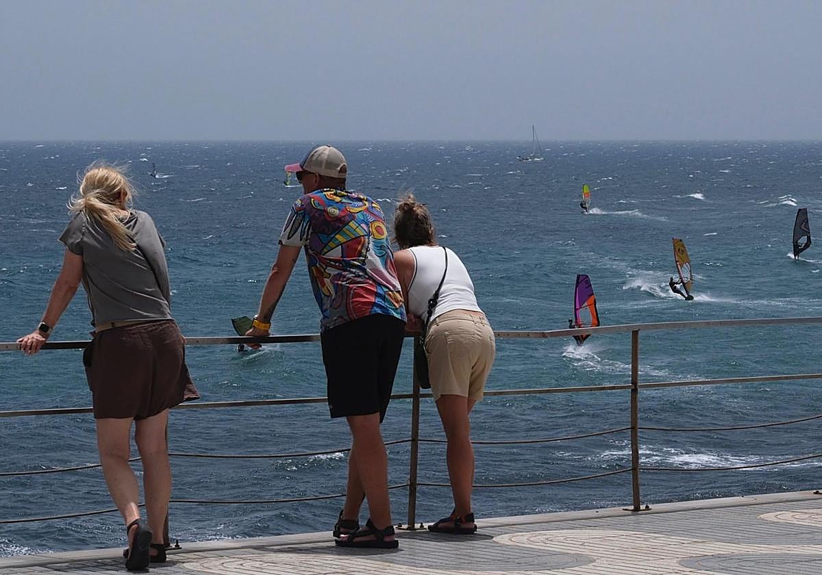 Turistas siguiendo este miércoles las cabriolas de windsurfistas en Pozo Izquierdo.