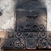 Detalle del dintel de la portada de la ermita de Puerto Escondido o la Capellanía, en La Oliva, con la cruz y las decoraciones vegetales y de aves quemadas.