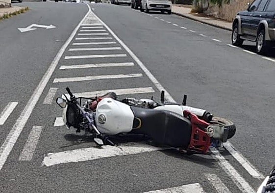 Imagen de la moto caída en el suelo.