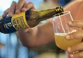 Persona echando la cerveza «Una Hora Menos» en una copa.