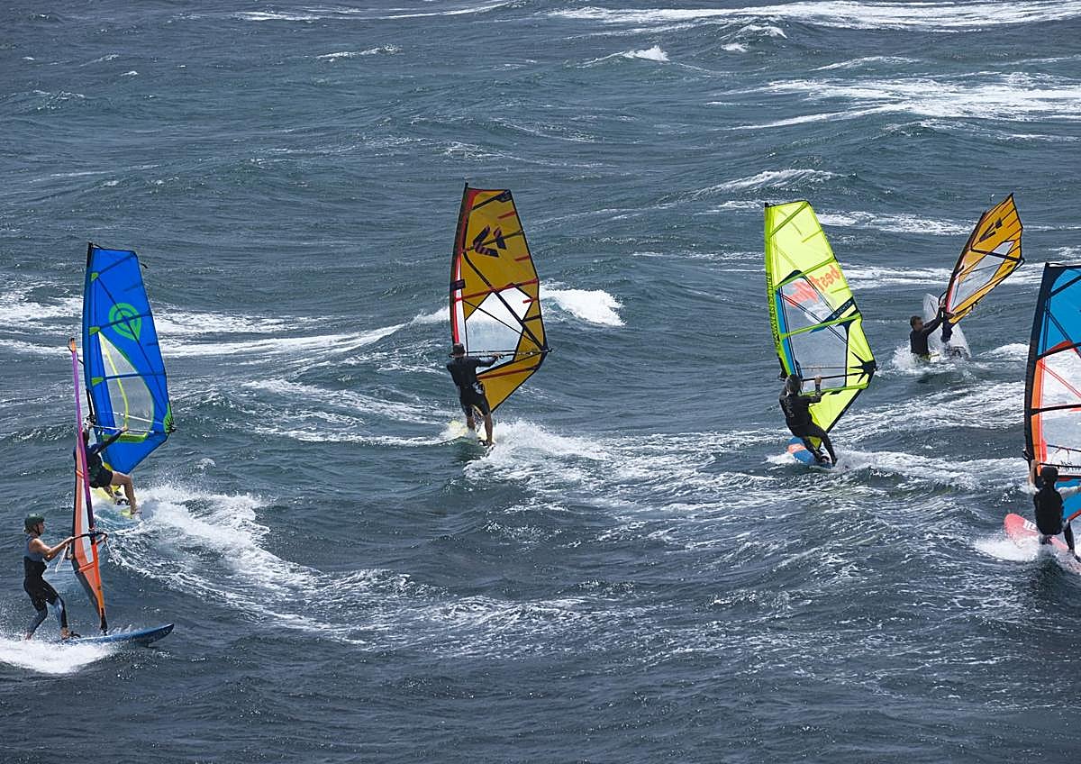 Imagen secundaria 1 - 1. Una montaña de sal en uno de los tajos de las salinas. 2. Windsurfistas surcando las olas de Pozo Izquierdo. 3. Un grupo de visitantes presta atención a las explicaciones de Navarro.