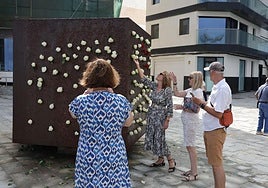 Familiares realizando la ofrenda en el Monumento El Cubo, en Las Palmas de Gran Canaria.