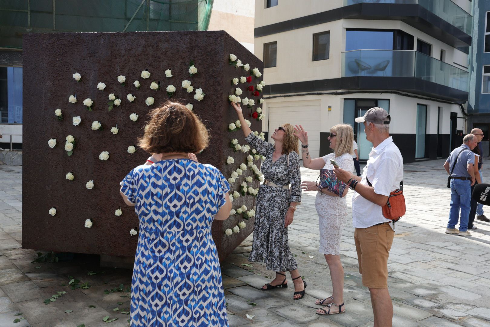 Familiares realizando la ofrenda en el Monumento El Cubo, en Las Palmas de Gran Canaria.