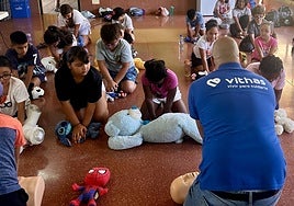 El director de enfermería de Vithas Canarias, Raico Pérez, les enseña a realizar la RCP con la ayuda de sus peluches.