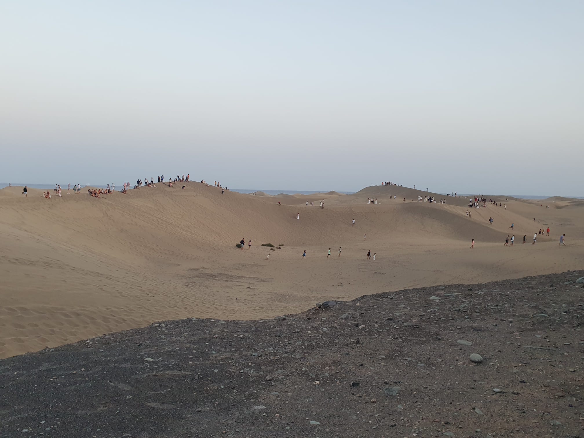 Imagen de personas saltándose las normas de seguridad y caminando sobre las dunas de Maspalomas.