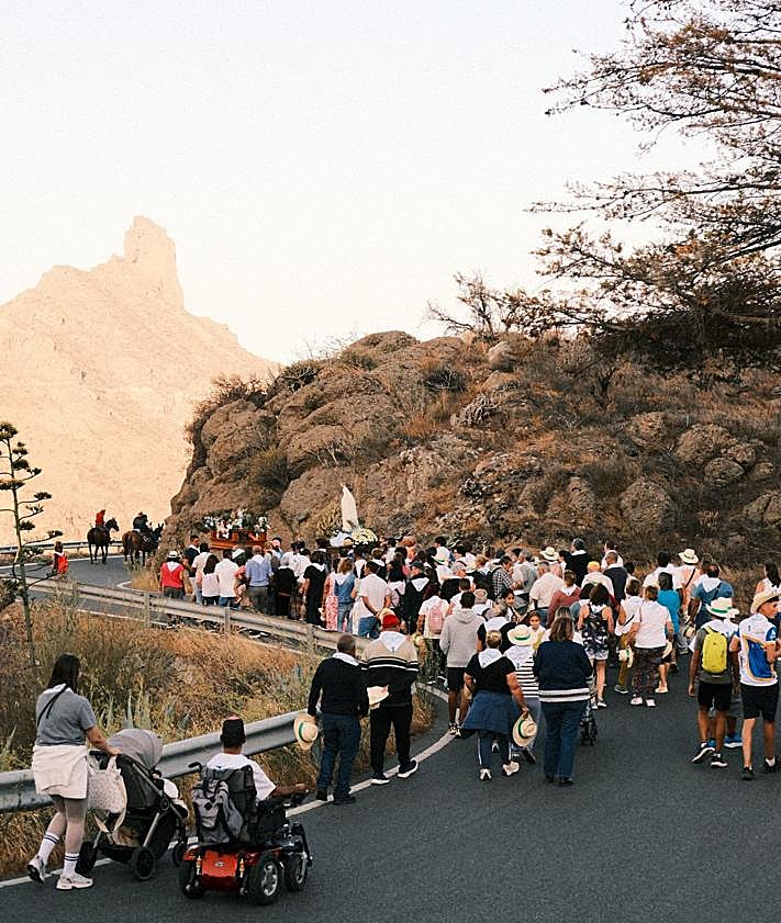 Imagen secundaria 2 - Almuerzo popular tras la misa. grupo folclórico dentro del templo y peregrinación de varias imágenes con el Roque Bentayga de fondo.