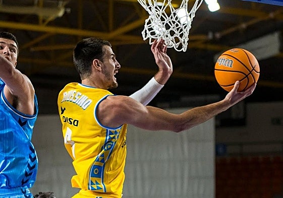 El alero argentino del Dreamland Gran Canaria, Nicolás Brussino, intenta anotar a aro pasado.