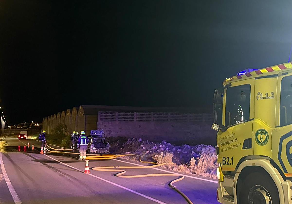 Bomberos extinguiendo el fuego del vehículo.