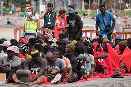 Imagen de los ocupantes del cayuco siendo atendidos por miembros de la Cruz Roja.