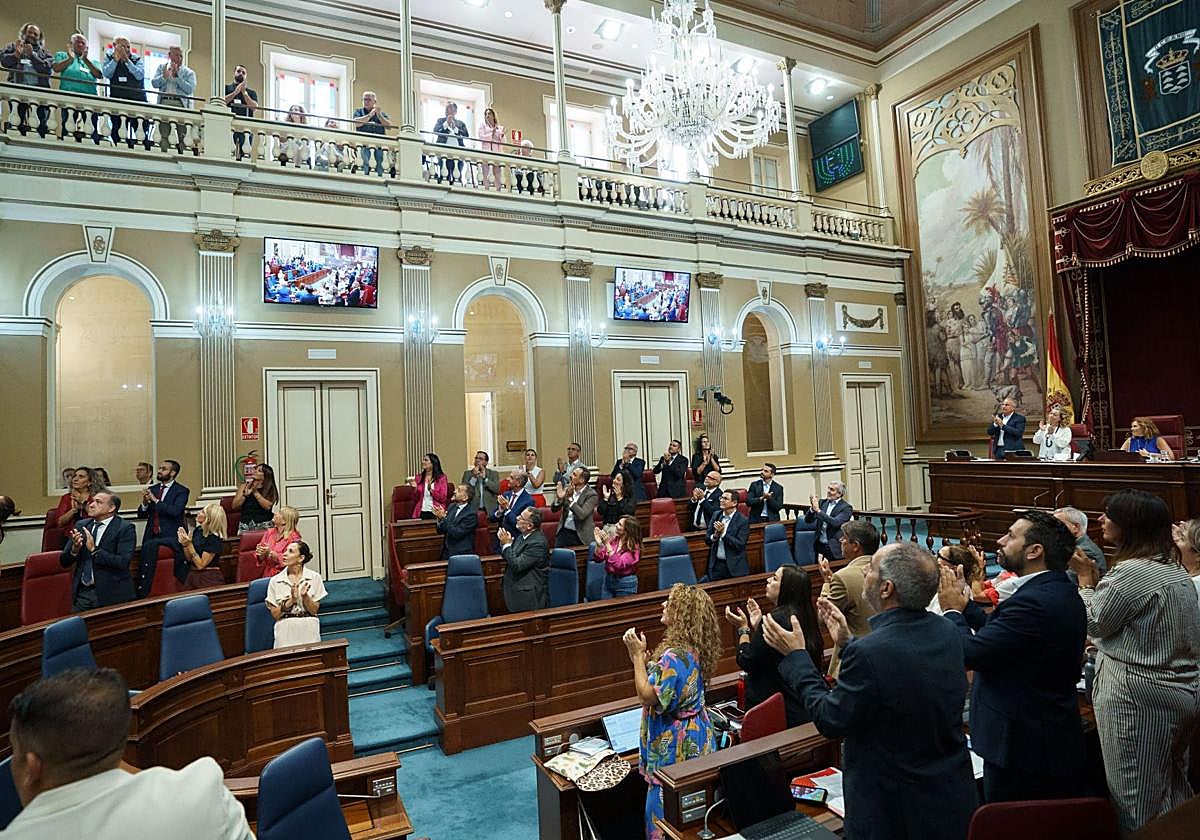 Los diputados del Parlamento de Canarias aplauden tras la aprobación de una ley.