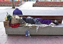 Una persona sin hogar duerme en un banco en el parque de Santa Catalina, en Las Palmas de Gran Canaria, en una imagen de archivo.