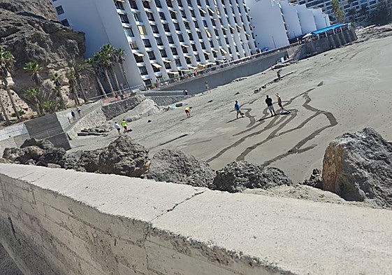 Operarios municipales de Mogán, este lunes, en plena tarea de limpieza de la playa de Patalavaca.