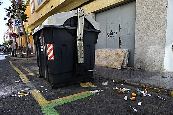 Colchones, residuos y suciedad, junto a un contenedor de la zona.