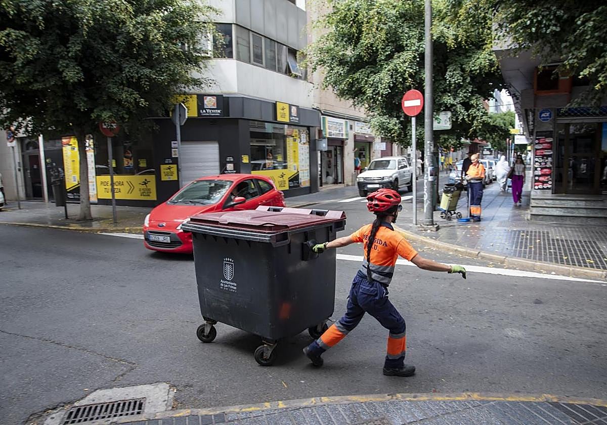 Una trabajadora retira un contenedor de basura en Las Palmas de Gran Canaria.