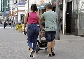 Pareja paseando con una criatura de corta edad.