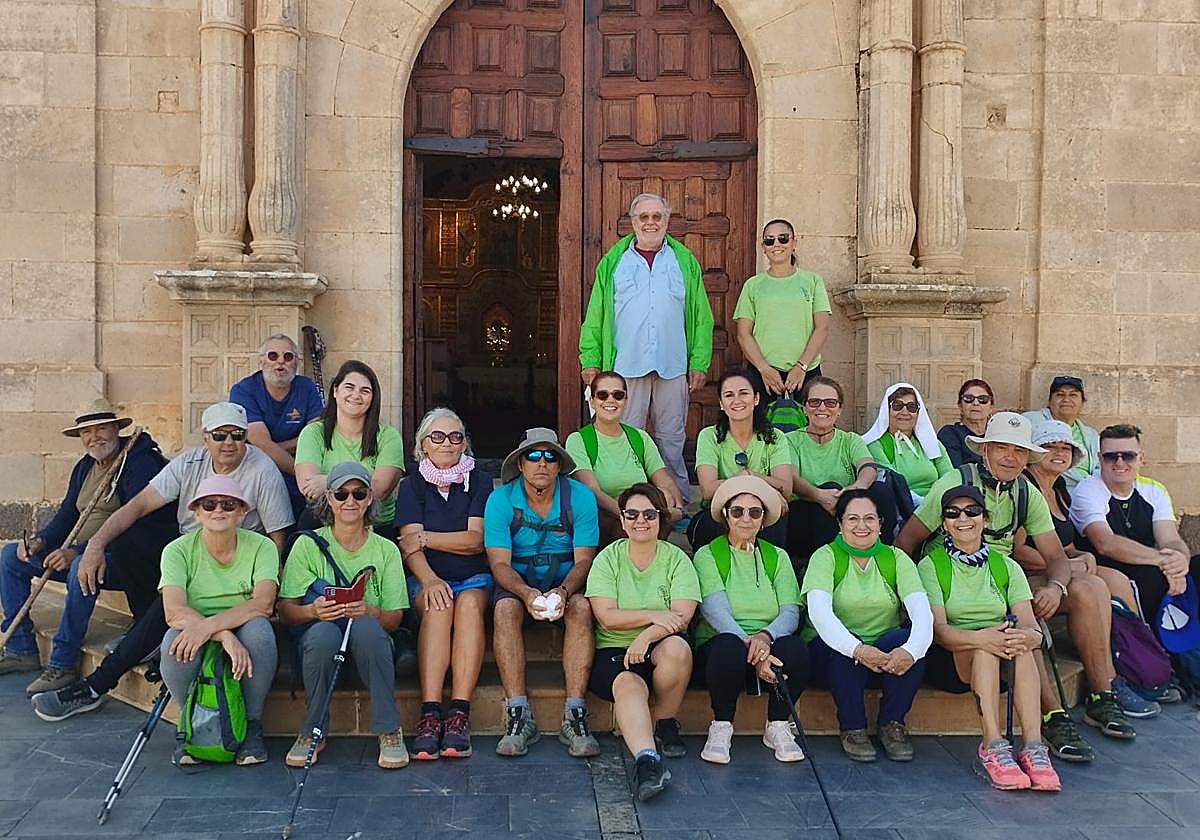 Los senderistas, con su guía, en la puerta del santuario de la Peña, en Vega de Río Palmas.