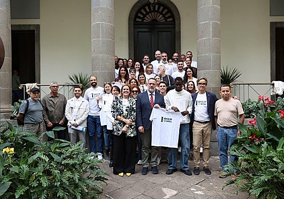 Personal y alumnado de Radio ECCA posan en el Parlamento junto a Poli Suárez tras aprobarse la ley.