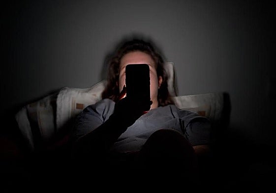 Foto de archivo de un joven con su teléfono móvil.