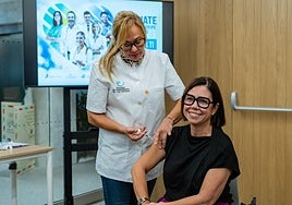 Una enfermera vacuna a la presidenta del Colegio de Farmacéuticos de Las Palmas, Loreto Gómez.