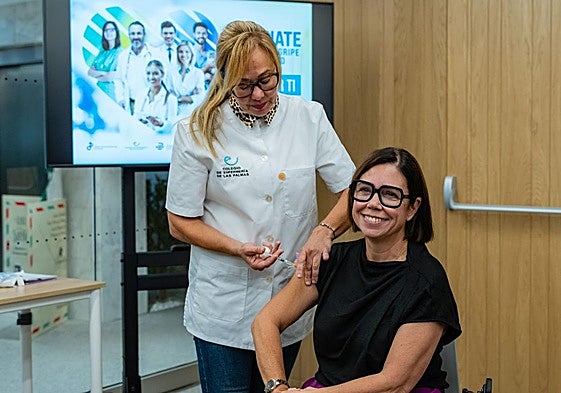 Una enfermera vacuna a la presidenta del Colegio de Farmacéuticos de Las Palmas, Loreto Gómez.