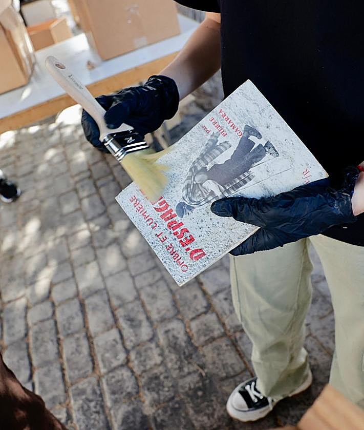 Imagen secundaria 2 - El concejal Leví Ramos durante la primera fase de recuperación y libros encontrados en las cajas.