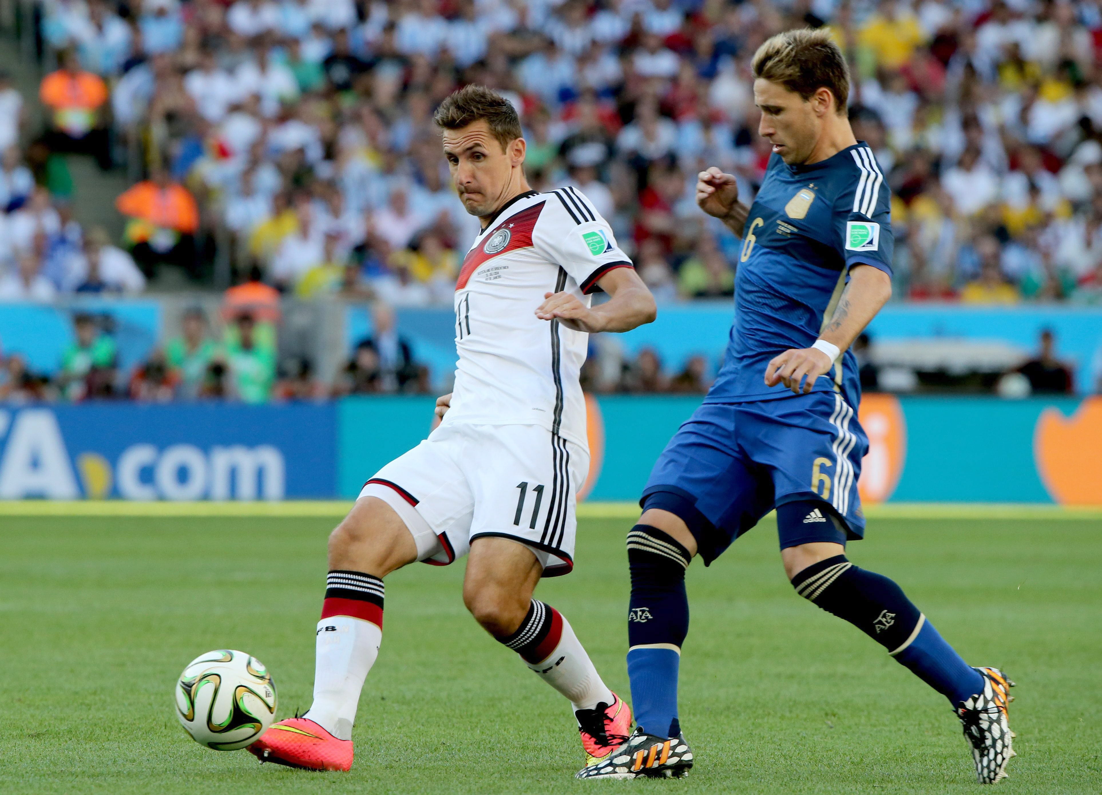 Klose (i) conduce el balón ante Biglia.