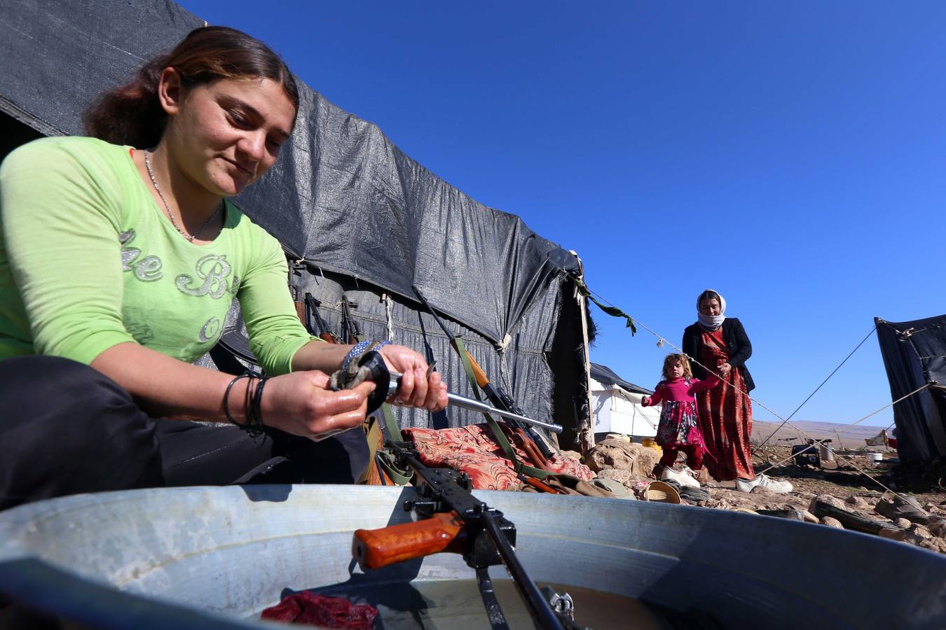 La lucha diaria. Una desplazada iraquí limpia un arma en un campo de refugiados.