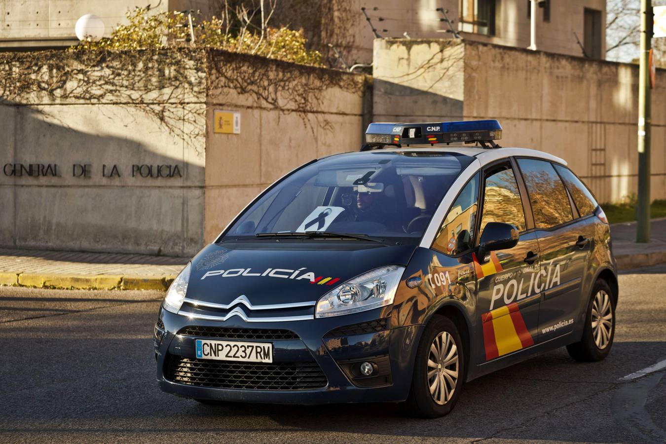 Un coche de Policía con un lazo negro acompaña al féretro con los restos mortales de Francisco Javier O.