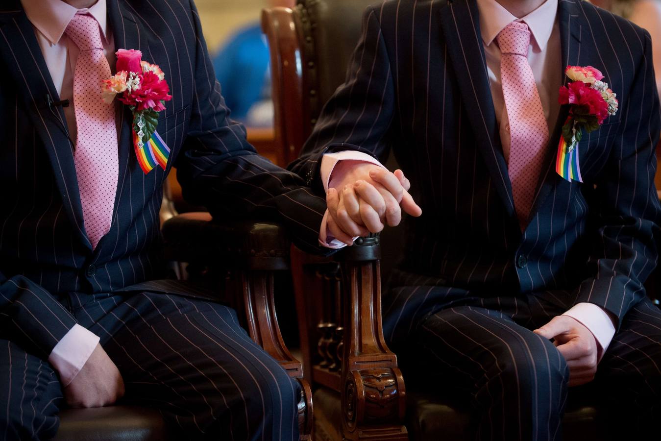 Phil Robathan y James Preston se dan la mano durante su ceremonia gay de boda en Brighton, al sur de Inglaterra, el 29 de marzo de 2014.