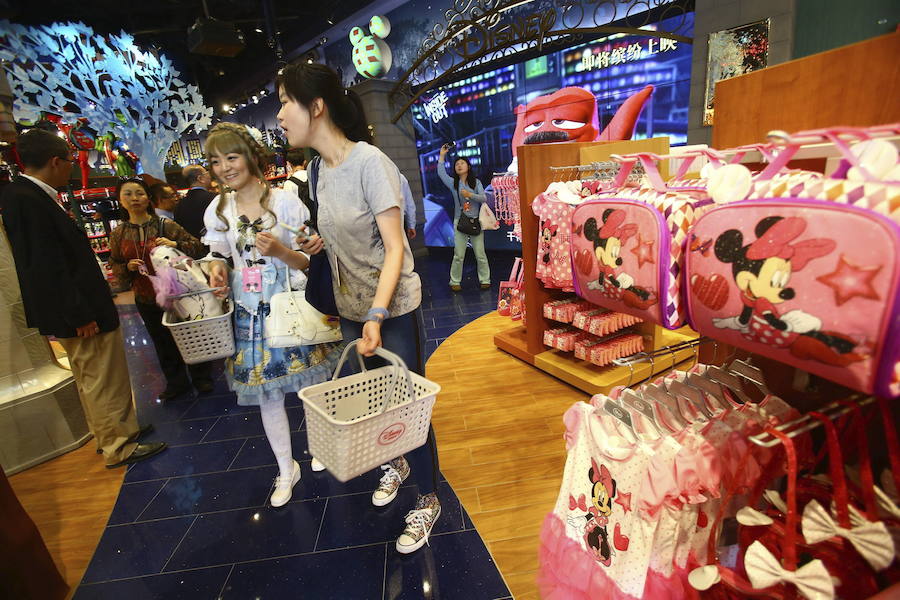Turistas compran y hacen fotos en la nueva tienda Disney de Disnayland Shanghái.