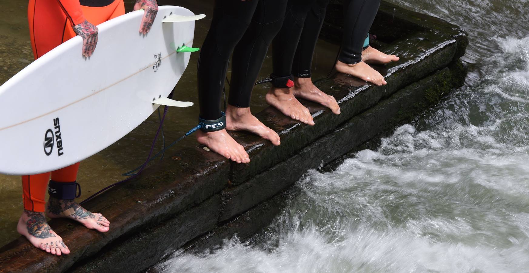 Jóvenes practican surf en el canal de Eisbach, al sur de Alemania