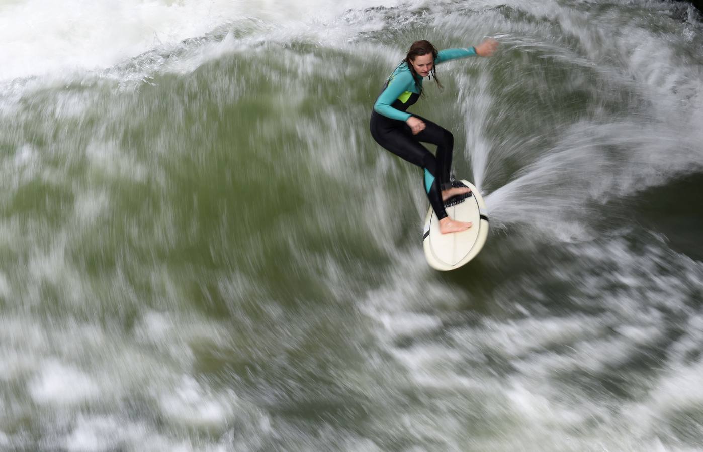 Jóvenes practican surf en el canal de Eisbach, al sur de Alemania