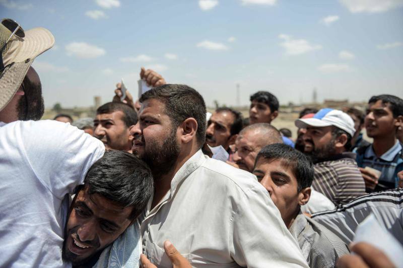 Ciudadanos iraquíes esperan para recibir comida