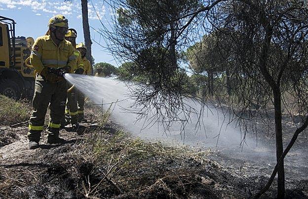 Efectivos del Infoca refrescan el paraje La Peñuela, en Moguer, en la mañana de ayer. 