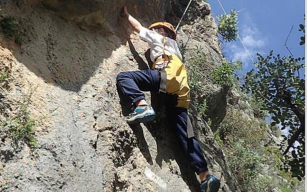 Escalada para niños en rocódromo natural.